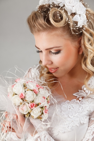Young bride in white wedding dress happy smiling with bouquet in handsの写真素材