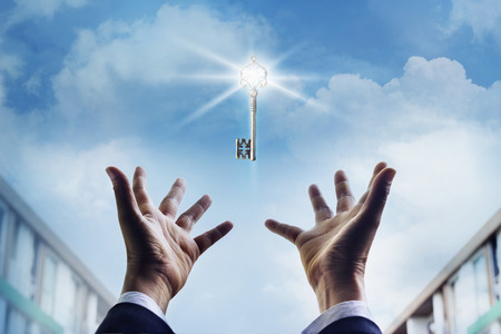 Hands of a businessman reaching to towards key success, business coneptの写真素材