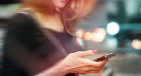 colorful woman useing on mobile phone, soft and blur conceptの写真素材