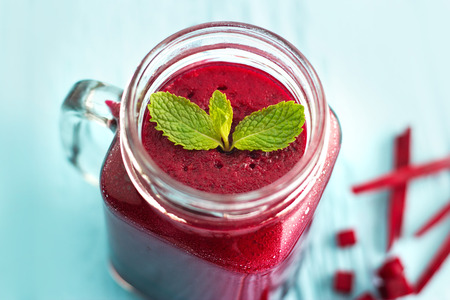 Beetroot smoothie healthy and mint herb on blue wooden backgroundの写真素材