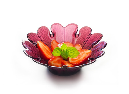 strawberry slice and mint in purple flower shape bowl on white background, soft focusの写真素材