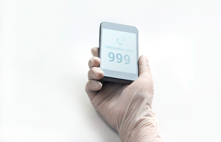 mobile phone and text emergency call in glove on white background, healthy conceptの写真素材