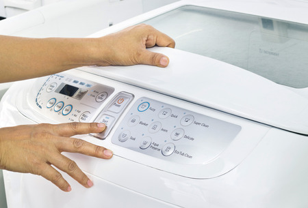finger press button start on white washing machineの写真素材