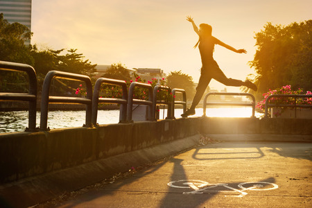 sport women jumping on the bike lane in the sunrise, soft focus and blurの写真素材