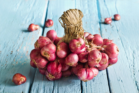Red onions group on blue wooden background, soft focusの写真素材