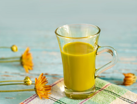 vintage color tone style of green tea latte on fabric and blue wooden, soft focus and blurの写真素材
