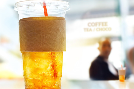 lemon ice tea in plastic glasses on restaurant background, soft focus and pastel color toneの写真素材