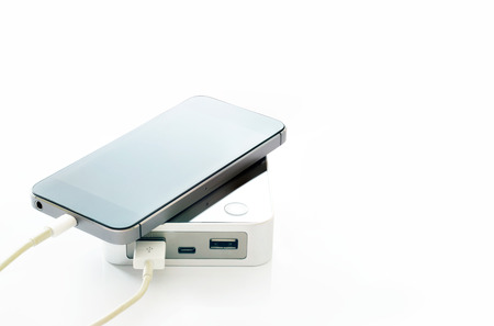 mobile smart phone smartphone charging with powerbank on white backgroundの写真素材