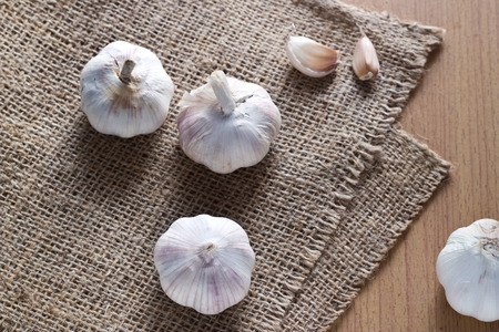 Garlic on the sack and wooden backgroundの写真素材