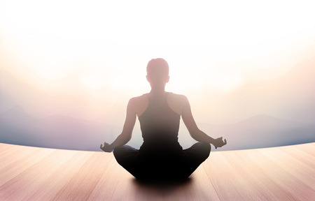 woman was meditating in morning and rays of light on landscape, vibrant soft and blur conceptの写真素材