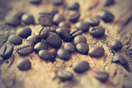 vintage color tone, coffee beans on the old wooden background, warm tone and soft focusの写真素材