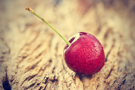 Vintage color tone style, cherry with water drops on the wooden background, soft focusの写真素材