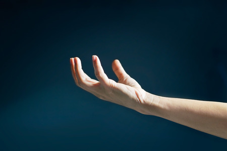 Human open empty hands with light on dark background,  blurred and soft focusの写真素材