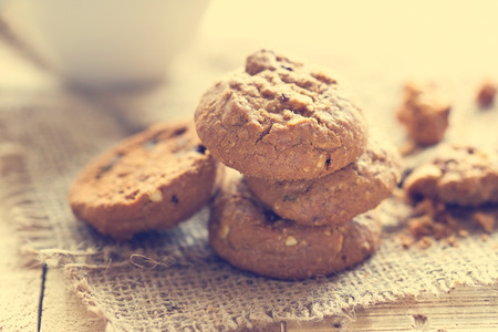 Chocolate chip cookies on sack on wooden table, Vintage color tone