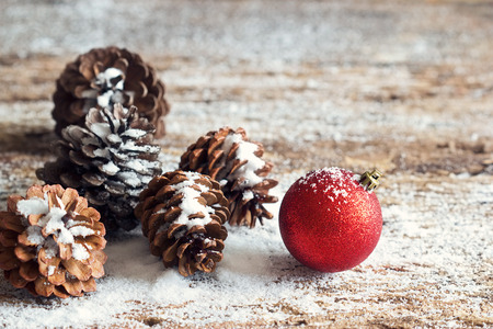 Red christmas ornament pine cones on woodenの写真素材