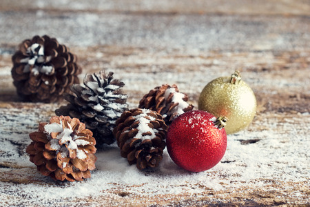 Red and gold christmas ornament pine cones on woodenの写真素材