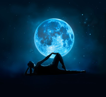 Abstract woman are yoga at blue full moon with star in dark night sky background, Moon original image from NASA.govの写真素材