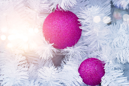 purple christmas ornament decorating on white christmas tree with lightingの写真素材