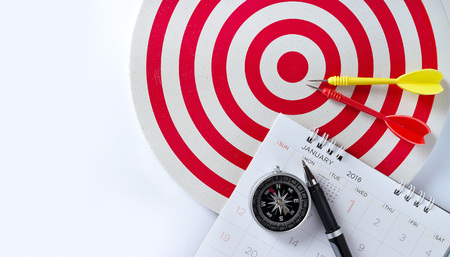 Sheet of a calendar with pen and compass, Red target with red and arrow on goal on white background, business conceptの写真素材