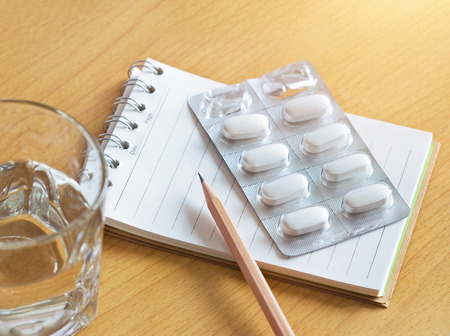 Pills in blister pack with note pad and pencil, Patient take note each time when take a pillの写真素材