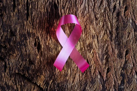 Pink ribbon, breast cancer awareness symbol on wooden backgroundの写真素材