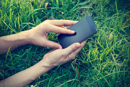 woman using mobile smart phone on grass in summer