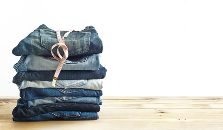 jeans with measure in shop on wooden shelf and white backgroundの写真素材