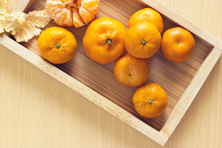 Orange fruits in tray wood on wooden background, Top viewの写真素材