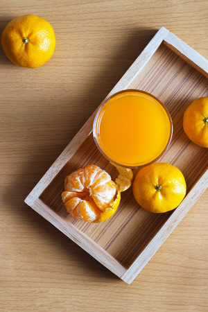 Orange and orange juice in tray wood on wooden background, Top viewの写真素材