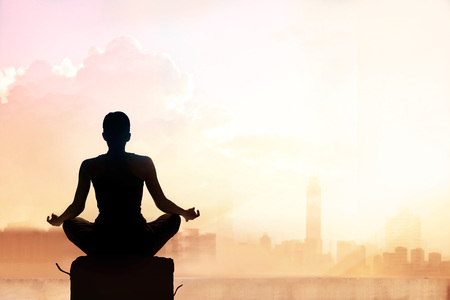 Abstract woman meditating on pastel color tone city in the sunsetの写真素材