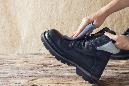 Cleaning shoes on wooden backgroundの写真素材
