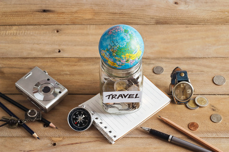 Money savings in a glass jar on wooden background, Travel conceptの写真素材