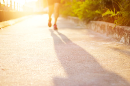 woman athlete running on street for healthy, blurred sports backgroundの写真素材