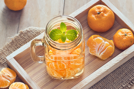 infusioned water of oranges in the mug on wooden backgroundの写真素材