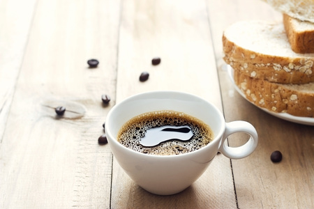 Black coffee and whole wheat bread for breakfast on wooden backgroundの写真素材