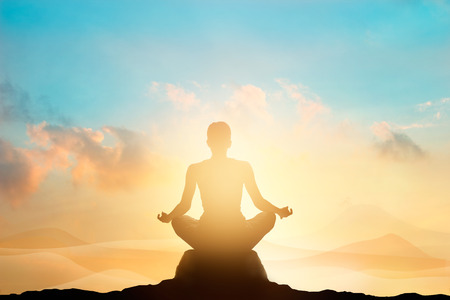 women meditating pastel on high mountain in sunset backgroundの写真素材