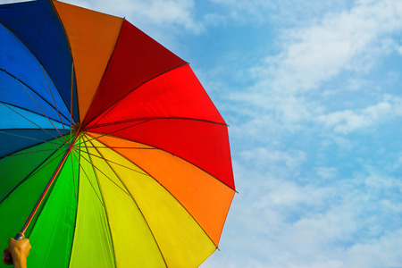 colorful rainbow umbrella on blue sky backgroundの写真素材