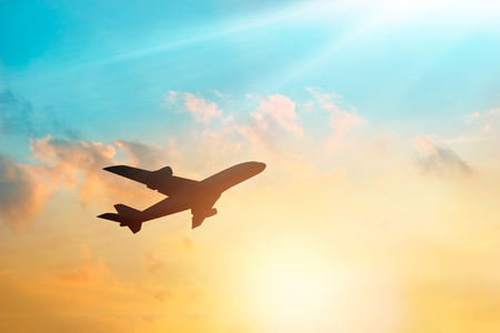 Airplane in the sky and cloud at sunsetの写真素材