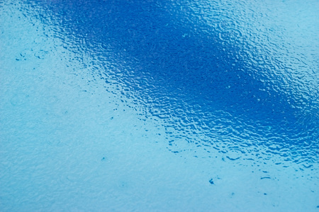 Raining drops in the swimming pool, soft focus and blur for backgroundの写真素材