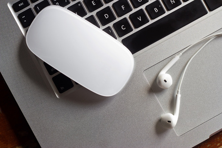 Mouse and earphone on laptop computer keyboard, concept for communication and musicの写真素材
