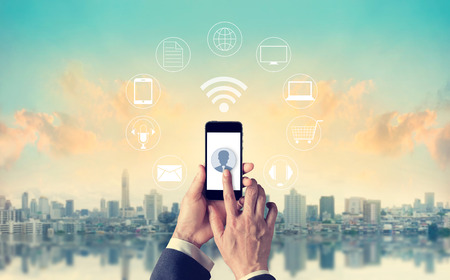 Man using mobile payments, holding circle global and icon customer network connection, Omni Channel or multi Channelの写真素材