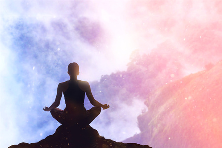 woman meditating colorful pastel on high mountain in sunset backgroundの写真素材
