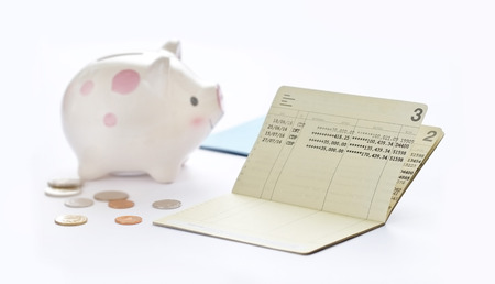 Saving account passbook, book bank and piggy bank on white backgroundの写真素材
