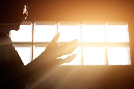 Respect and pray in the room with sunrise through window backgroundの写真素材