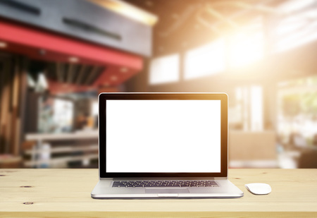 Laptop computer with blank screen on wood table in architect office backgroundの写真素材
