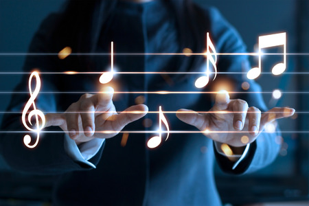 Woman hands playing music notes on dark background, music conceptの写真素材