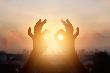 Woman hands in lotus position of yoga and meditation, silhouette on nature sunset backgroundの写真素材