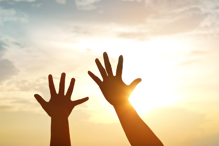silhouette hands mother and son on sunset backgroundの写真素材