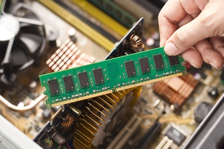 Hand with memory on a computer motherboardの写真素材