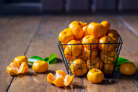 Orange fruit in basket on wooden backgroundの写真素材